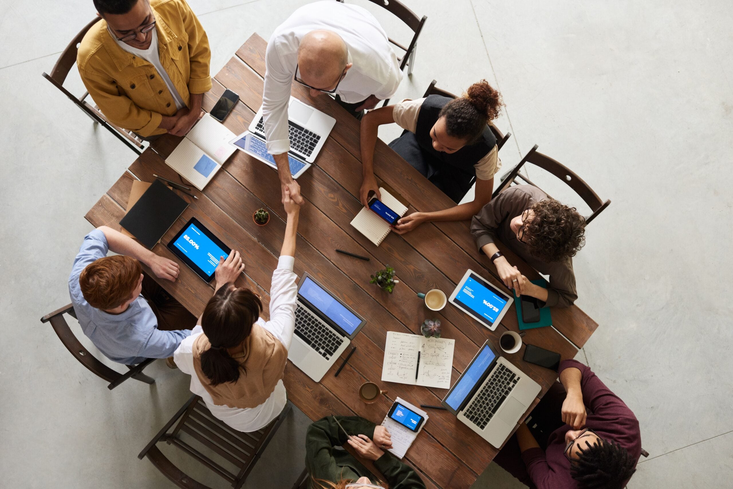 Team gathered around a laptop reviewing analytics dashboards and reports during a project debrief.